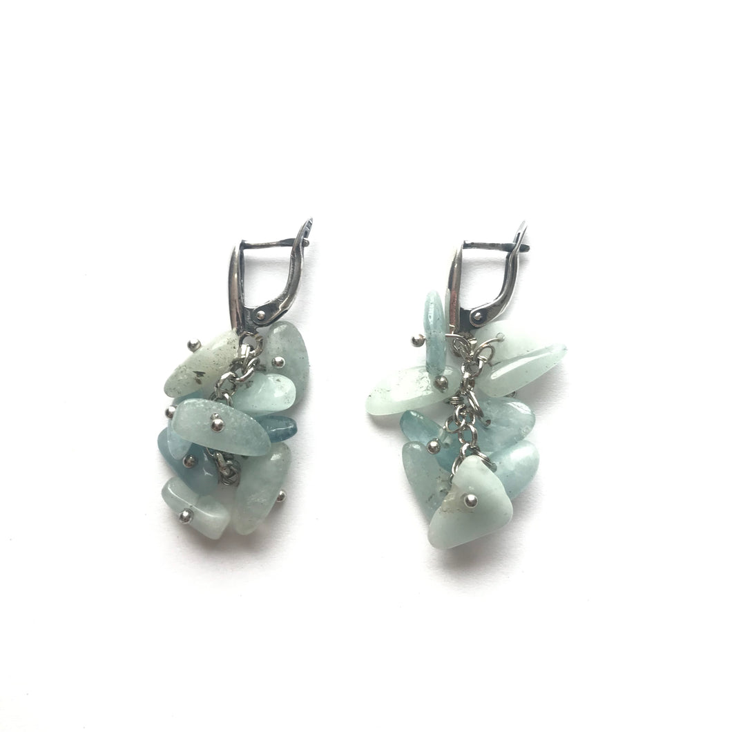 Collection of Aquamarine stone dangling earrings with silver clasps.